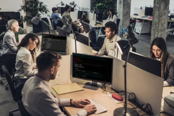 Image of people in front of their workstations facing their pc.