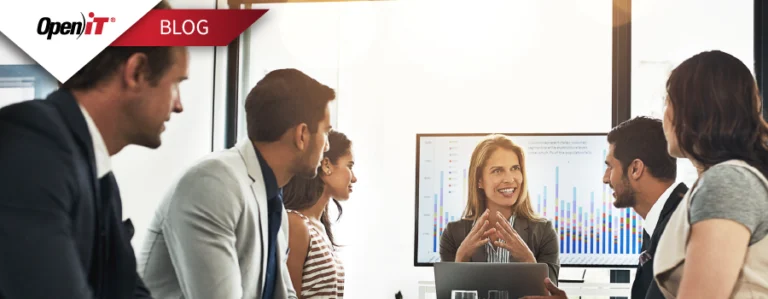 A team in a business meeting discussing software usage metrics, with a woman presenting audit data on a screen—representing Open iT's solution to stop the $500K software license audit drain.