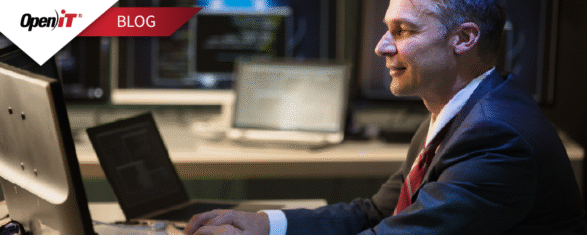 a professional in a suit working on a laptop in a control room environment with multiple monitors. represents open it’s software license inventory management, emphasizing monitoring, tracking, and optimization of software licenses for enterprise use.