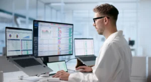 Engineer reviewing software license usage dashboards with charts and reports across multiple monitors