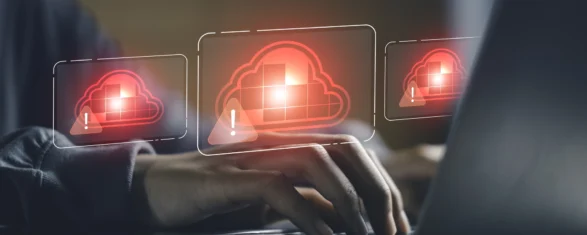 Ingénieur tapant sur un ordinateur portable sur lequel s'affichent des icônes d'avertissement en forme de nuage rouge indiquant que les emprunts de licences logicielles cloud ont été refusés