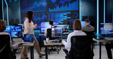 Team monitoring real-time data dashboards on multiple screens in a modern operations center