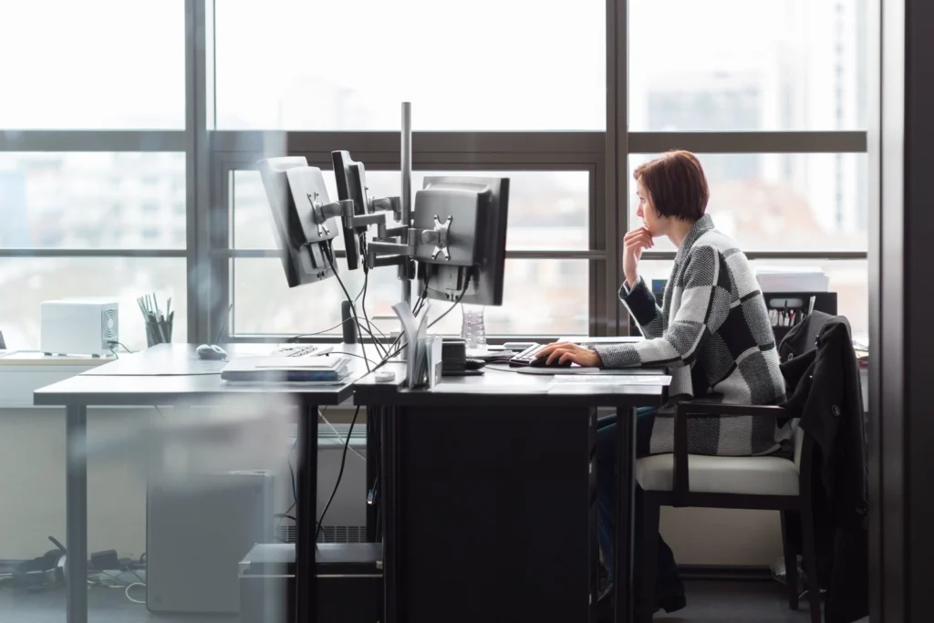 Engineer working at a multi-monitor workstation in an office